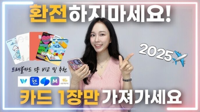 여성이 스마트폰을 들고 미소를 지으며 손가락으로 숫자 1을 가리키고 있다. 화면에는 '환전하지마세요! 카드 1장만 가져가세요'라는 문구와 다양한 트래블카드 이미지, 은행 로고, 비행기 이모지, '2025' 텍스트가 보인다.