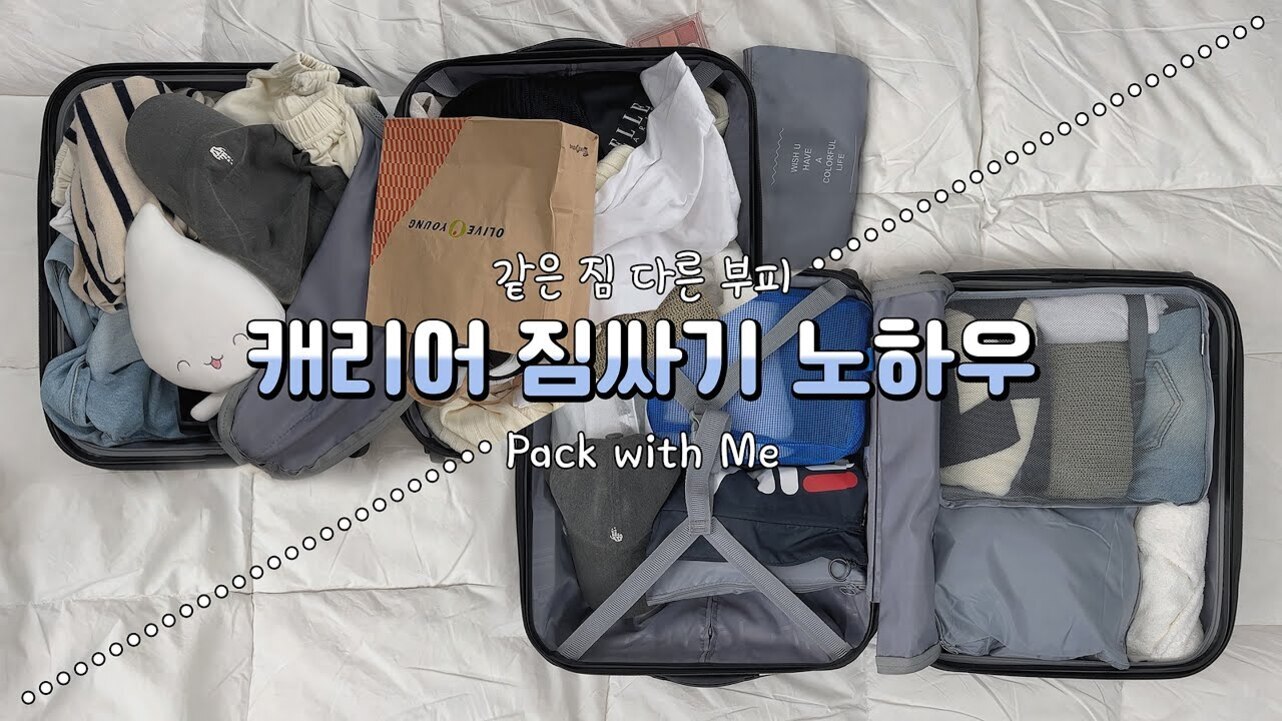 침대 위에 펼쳐진 두 개의 캐리어에 옷과 소지품이 정리되어 들어있고, 중앙에는 '같은 짐 다른 부피 캐리어 짐싸기 노하우 Pack with Me'라는 글자가 적혀 있다.