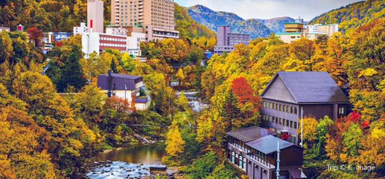 가을 단풍으로 둘러싸인 계곡과 그 주변에 위치한 여러 건물들, 뒤로 산이 펼쳐져 있다.